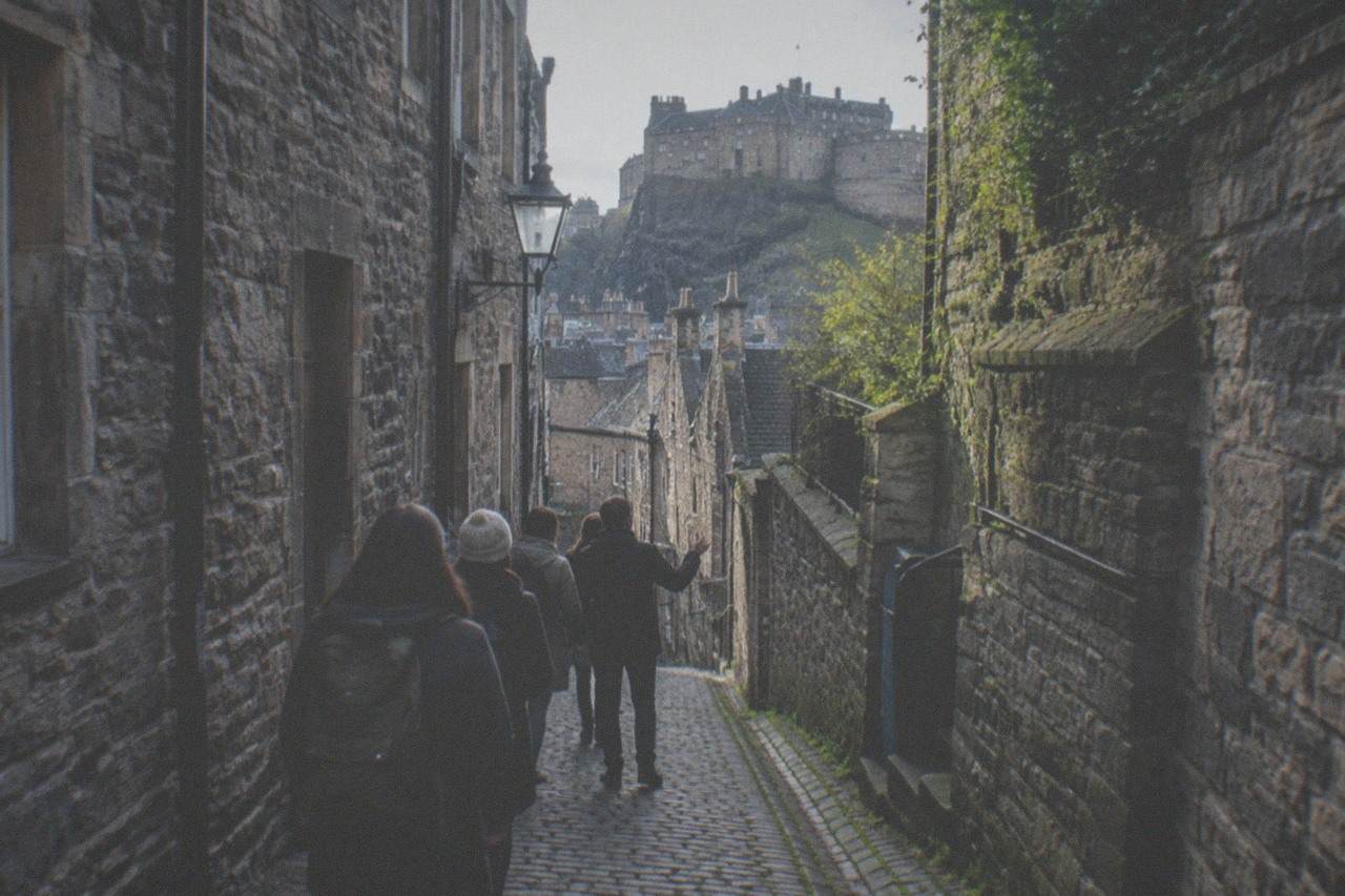 A narrow close between tall stone tenement buildings on the Royal Mile in Edinburgh