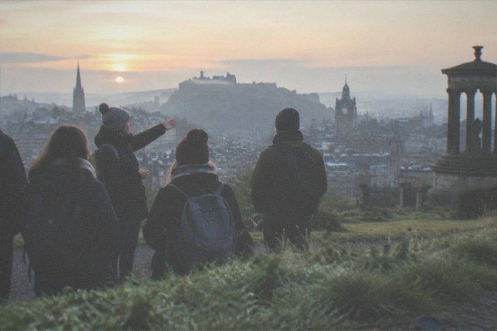 Edinburgh Castle on its rock above the city skyline with gardens in the foreground