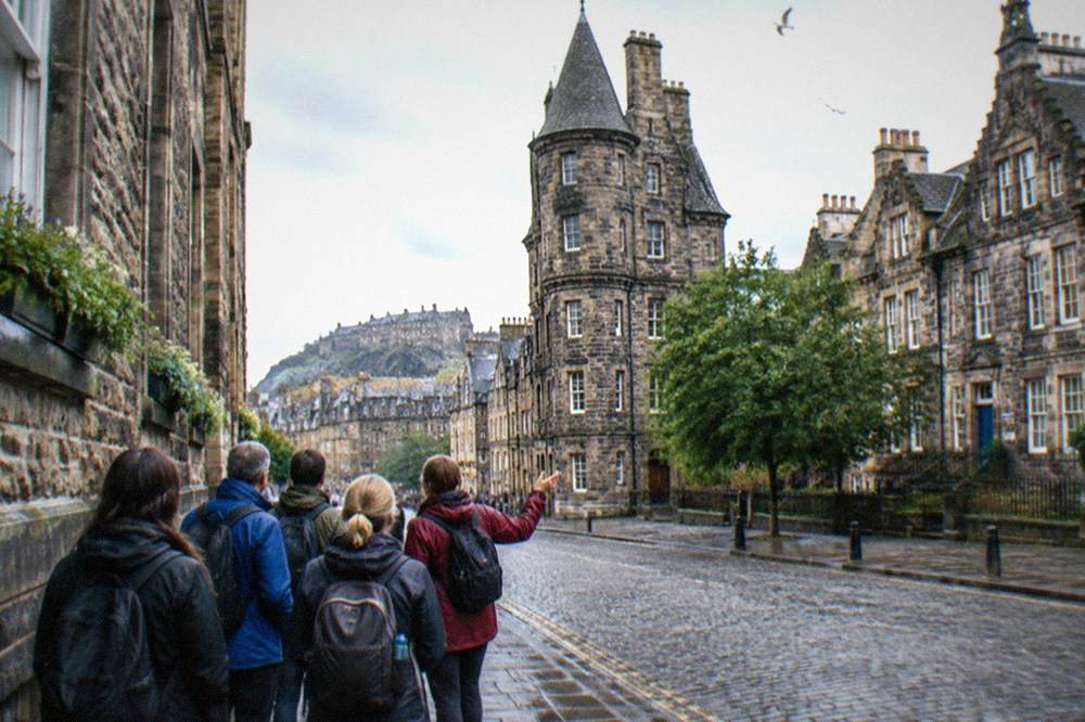Historic museum building on a cobbled Edinburgh street with a stone tower
