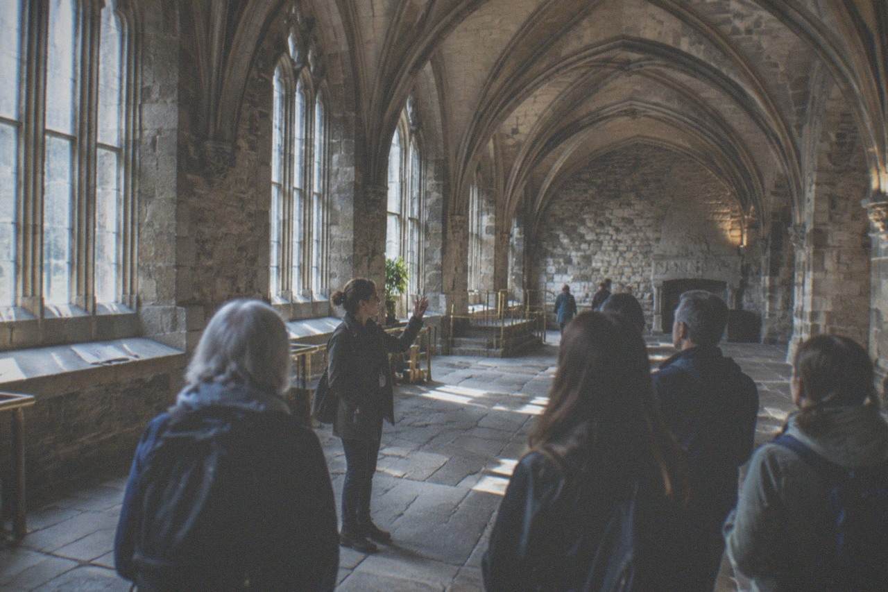 Grand gallery hall with tall stone columns and natural light falling on display cases