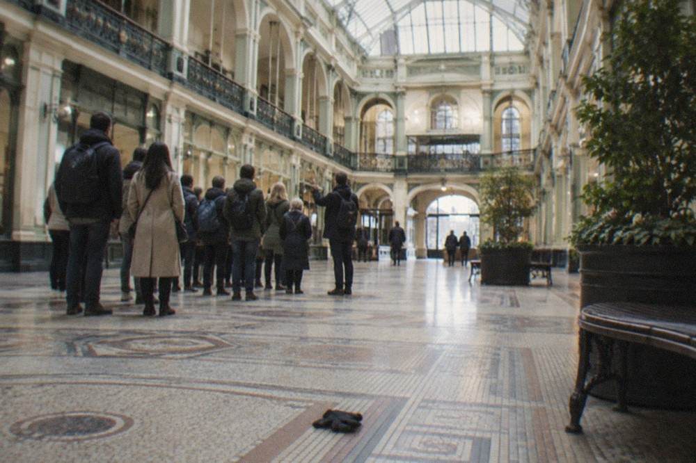 Grand Victorian interior of the National Museum of Scotland with a high glass roof and balconies overlooking the central hall.