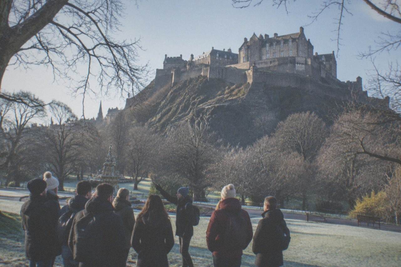 Edinburgh Castle seen from gardens below with the city skyline behind it