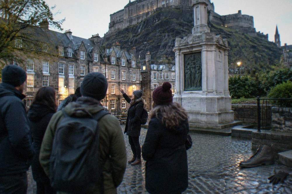 Greyfriars Kirkyard gravestones with Edinburgh tenements rising behind the wall