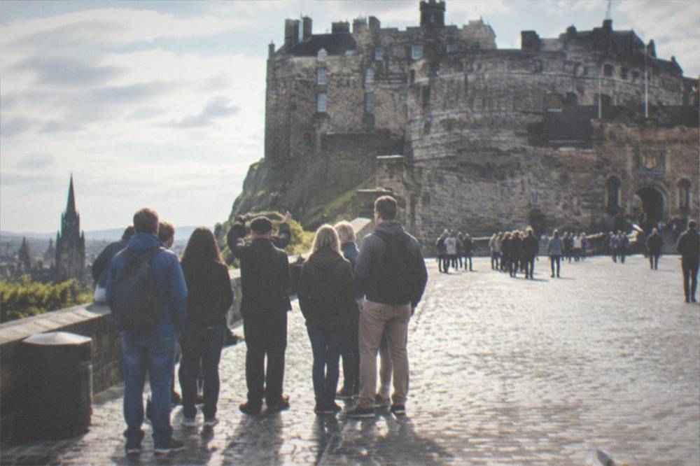 Tourists gathered at the castle entrance gatehouse on a busy afternoon