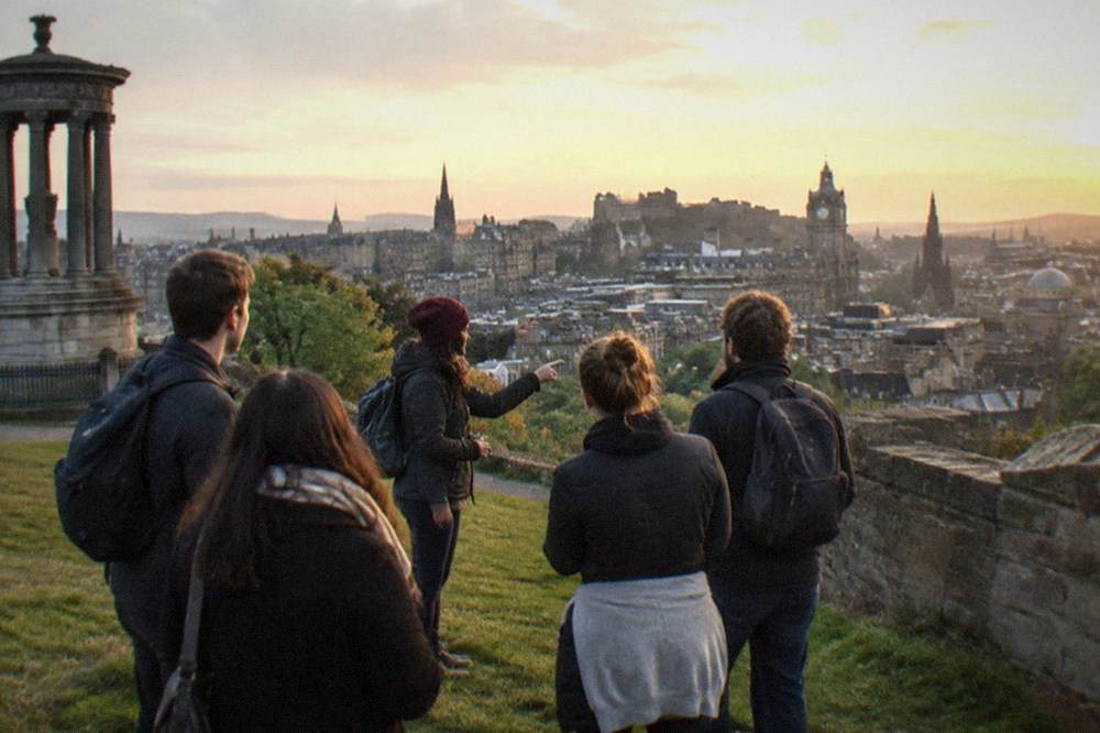 A hilltop viewpoint overlooking Edinburgh's spires and hills at golden hour