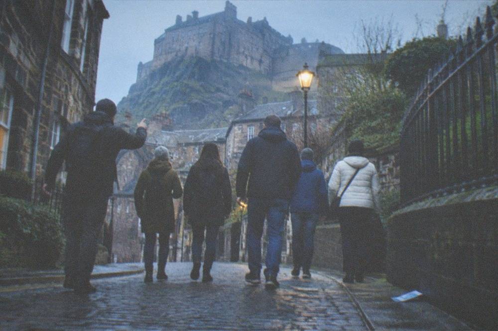 A narrow Old Town close with tall stone buildings curving uphill