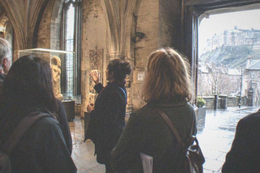 A grand gallery hall with sculpture and paintings under a glass roof