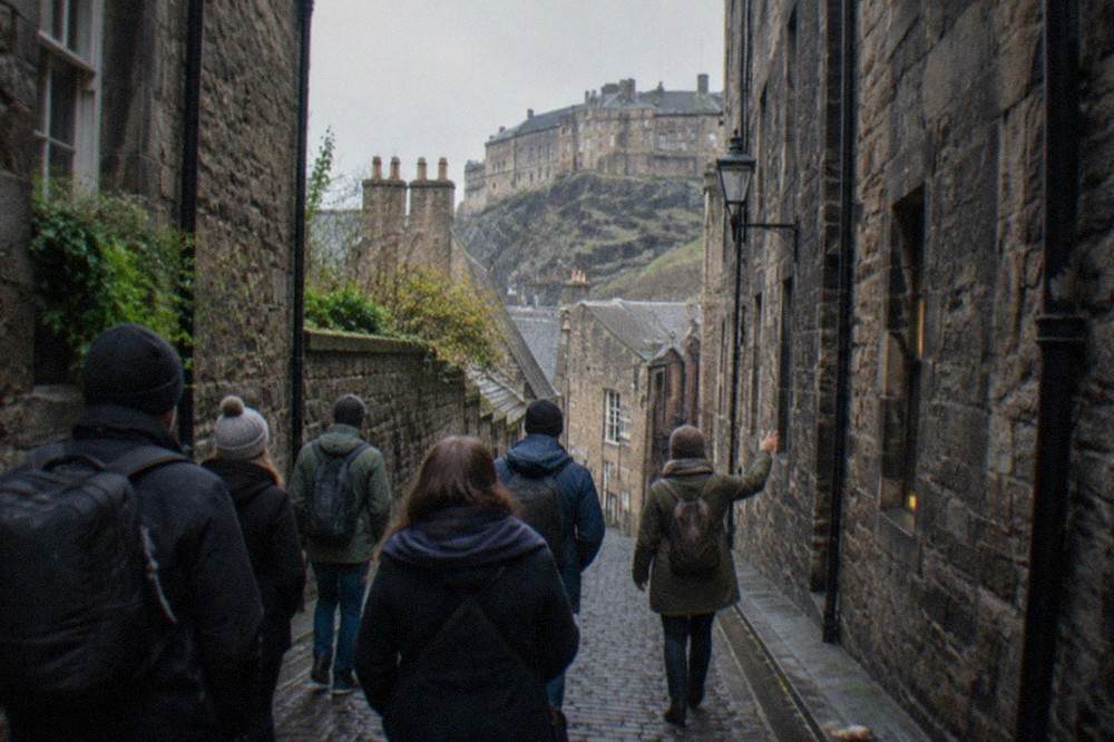 A narrow cobbled close between tall stone tenement buildings in Edinburgh's Old Town