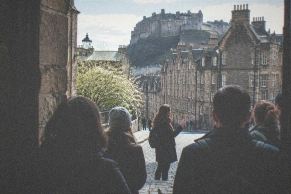 A guide addressing a small group of visitors on the Royal Mile in Edinburgh