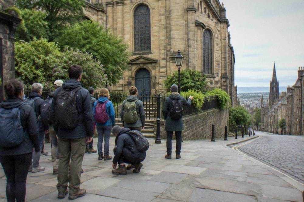 Guide speaking to a gathered group on a stone street in the Old Town